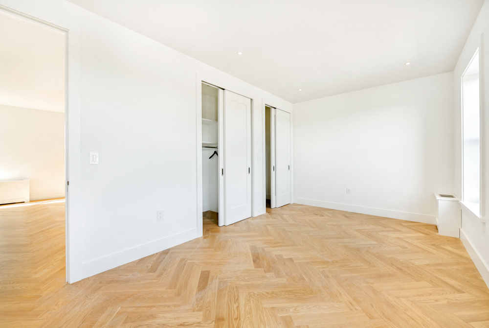 an empty living room with white walls and wood floors
